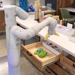A robotic arm controlled by PaLM-E reaches for a bag of chips.