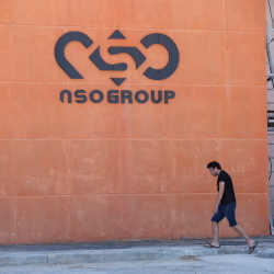 A pedestrian walks past a branch of the Israeli NSO Group.