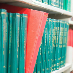 volumes of research journals on a library shelf