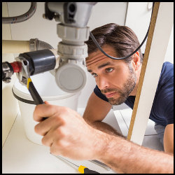 plumber working under a sink