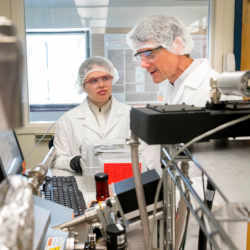 OSU's Jessica Peterson (left) and John Conley discuss the operation of an atomic layer deposition (ALD) systems.