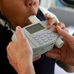 An 8-year-old student blows into a spirometer held by a nurse outside an elementary school in Bel Nor, MO. 