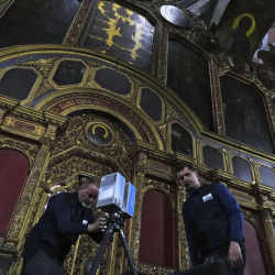 Volunteers Emmanuel Durand, left, and Serhii Revenko set up a high-tech scanner at the All Saints Church at the Kyiv-Pechersk Lavra in Kyiv, Ukraine.