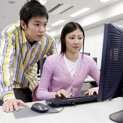 male and female students look at a computer display