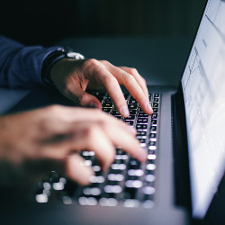 hands typing on a laptop computer