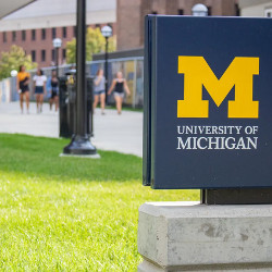 co-eds walking on campus, and a University of Michigan sign