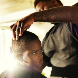 black haircutter and boy in barber's chair