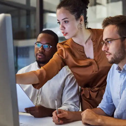 two workers watch a computer display during a training session