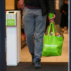 A customer leaves an Amazon Fresh cashierless convenience in London. 