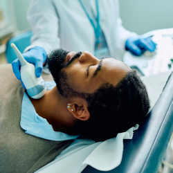 An African-American man receives an ultrasound.