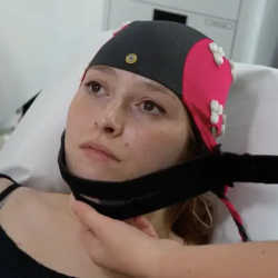 A woman being fitted with the brain-wave cap.