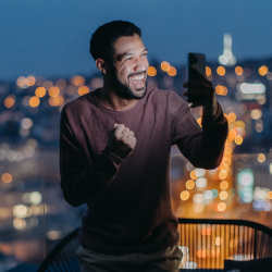 A young man takes a selfie on a balcony.