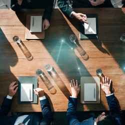 businessmen seen from above sitting at a meeting table
