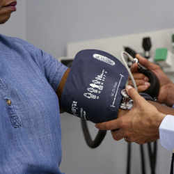 Measuring the blood pressure of a Black woman.