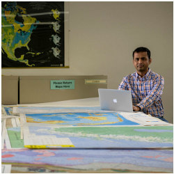 Satish Puri with printed maps in Missouri S&T's Curtis Laws Wilson Library