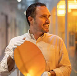 Alvaro Casas Bedoya holding a silicon wafer used in chip manufacturing.