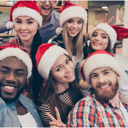 workers in Santa hats at holiday office party