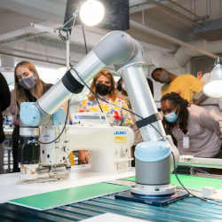 A robotic arm positions pieces of stiffened fabric for a demonstration of automated sewing at the Industrial Sewing and Innovation Center in Detroit, MI.
