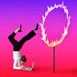 coder in unnatural position at a laptop computer next to a ring of fire