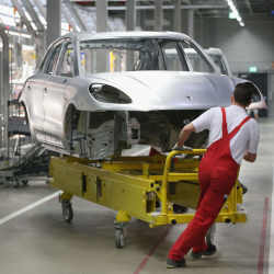 Factory workers assembling a Porsche Macan. 
